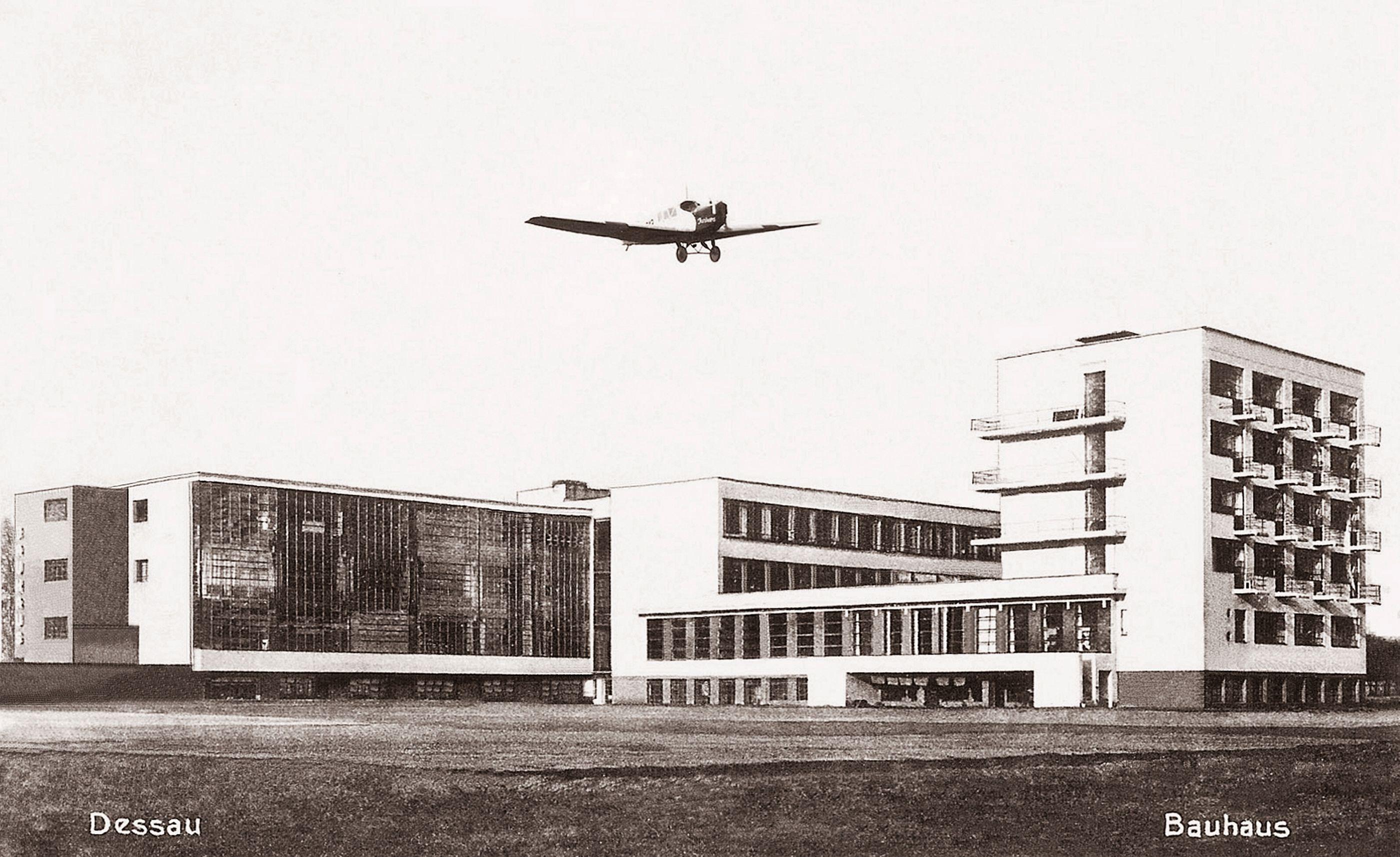 Eine Junkers F 13 überfliegt das Bauhausgebäude Dessau in

West-Ost-Richtung. Historische Ansichtskarte, um 1927