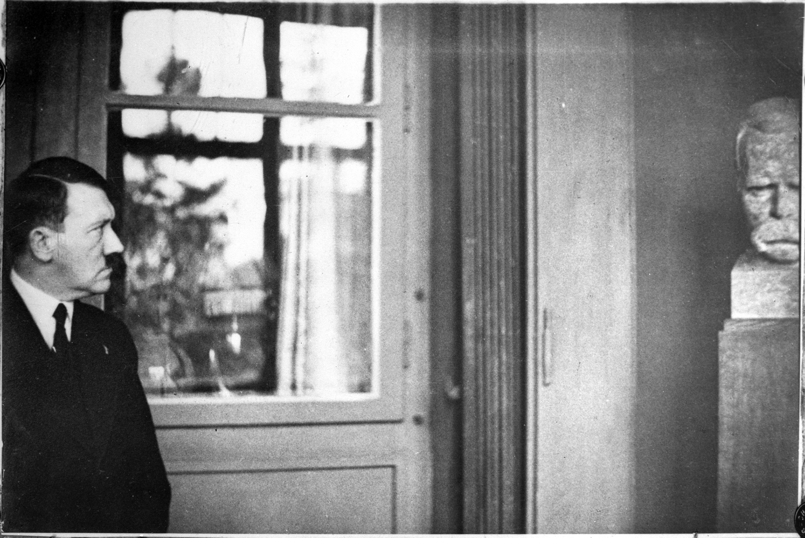Adolf Hitler im Nietzsche-Archiv neben einer Nietzsche-Büste von Fritz Röll, 1932